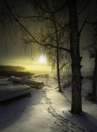 Someone went fishing in the misty morning and sun in the cold winter of Swedenの写真素材