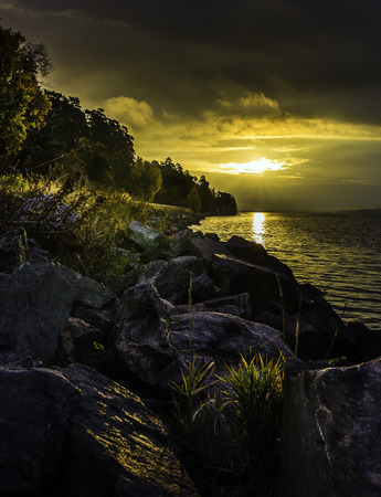 Warm sunlight as the sun rises over the ocean in Swedenの写真素材