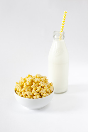 Corn Flakes in the form Stars in the Bowl with bottle milk Isolated Top View on White Backgroundの写真素材