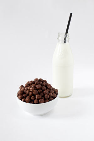 Corn Flakes Chocolate Balls in the Bowl with bottle milk Isolated Top View on White Backgroundの写真素材