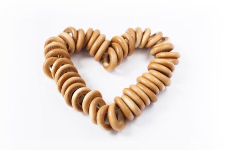 Bunch of bagels in the shape of a heart, isolated on white backgroundの写真素材
