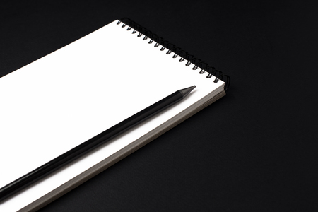 Opened clean notebook or sketchbook with pencil on black backgroundの写真素材
