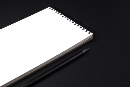 Opened clean notebook or sketchbook with pencil on black backgroundの写真素材
