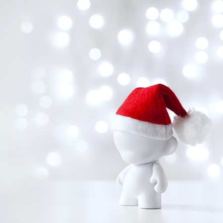 Christmas cute toy in Red Hat Santa Claus, Symbol New Year, Defocused Lights White Backgroundの写真素材