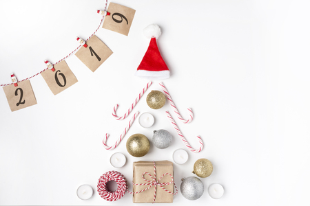 Christmas tree from golden and silver balls, gift, candles, lollipops, red hat santa claus, notes with wish on clothespins, Top view White Background Christmas New Yearの写真素材