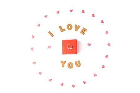 Valentine's day concept. Declaration of love, frame made of paper hearts. In the center red gift box with ring. Flat lay, top view, white background, isolated, copy spaceの写真素材