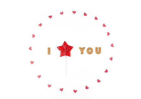 Valentine's day concept. Declaration of love, frame made of paper hearts, lollipop in form star. Flat lay, top view, white background, isolated, copy spaceの写真素材