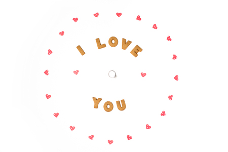Valentine's day concept. Declaration of love, frame made of paper hearts. In the center engagement ring. Flat lay, top view, white background, isolated, copy spaceの写真素材