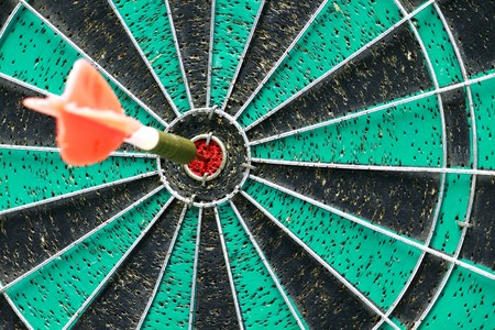 Darts board with single arrow in bullseyeの写真素材