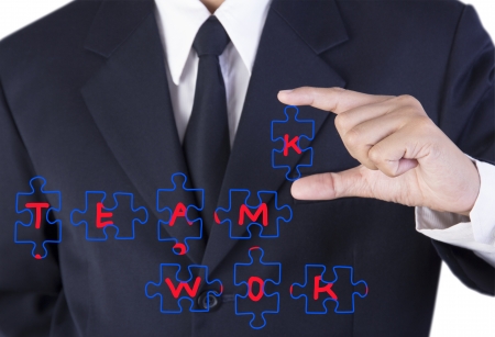 finger businessman holding jigsaw teamwork の写真素材