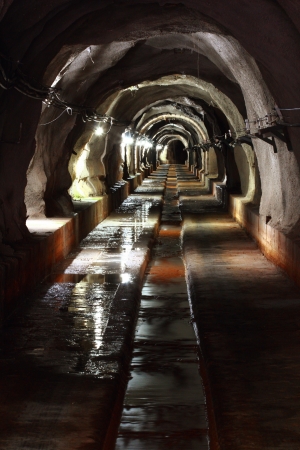 long walk way in dark tunnel with light の写真素材