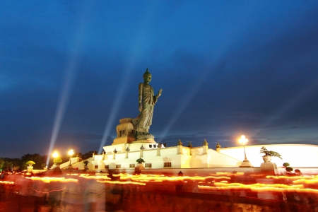 People walks with lighted candles in hand around buddha imageの写真素材