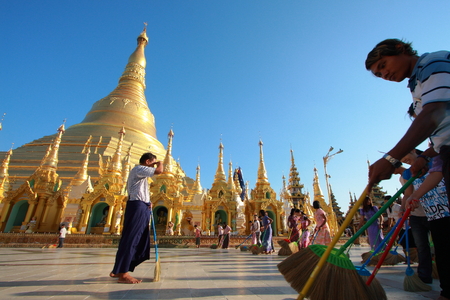 YANGON, MYANMAR - FEB 13: Buddhist devotees sweep the compound at the Shwedagon Pagoda on February 13, 2011 in Yangoon, Myanmar (Burma).のeditorial素材