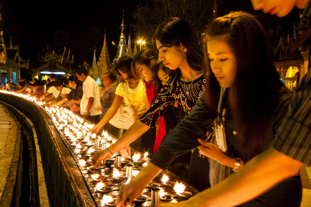 YANGON, MYANMAR - FEBRUARY 13: Buddhist devotees lighting candles at the Shwedagon Pagoda on Feb 13, 2011 in Yangon, Myanmar (Burma).のeditorial素材