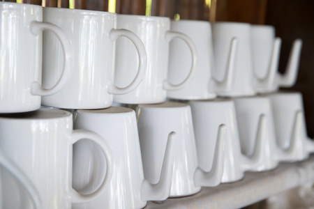 white cups stack on shelf with sunlightの写真素材