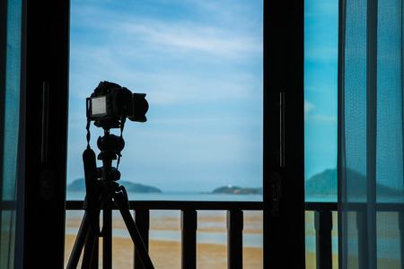 Silhouette camera on tripod at porch outside the room in the morning that can shoot beautiful landscape view by remote or wireless anytime,の写真素材