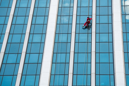 group of workers cleaning windows service on high rise building, wide shotの写真素材