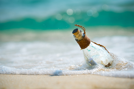 Letter message in a glass transparent bottle on the beach , concept for communication.の写真素材