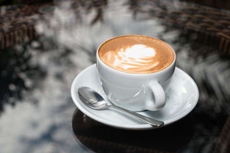 Cup of coffee on table background.