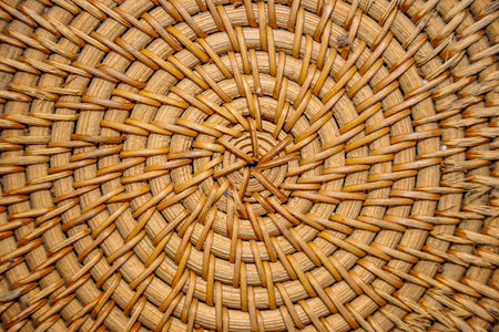 Close-up of a woven basket showcasing intricate circular patterns and textures, perfect for backgrounds and design elements.の写真素材