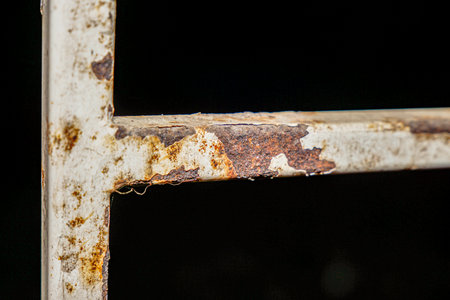 Close-up of weathered and rusted metal structure against a dark background, showcasing decay and age, perfect for industrial or abstract concepts.の写真素材