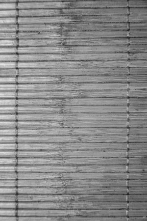 Close-up of a textured bamboo mat, creating a natural and minimalist background, perfect for adding an organic touch to designs and providing a sense of calm.の写真素材