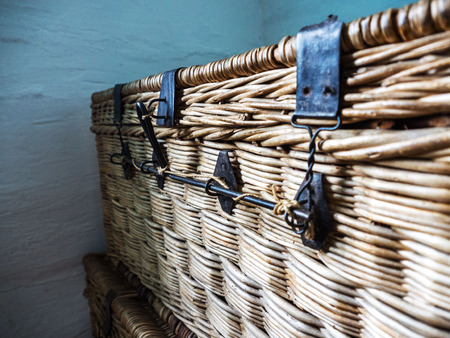 Retro wicker bag on a wooden table. Metal latches.の写真素材