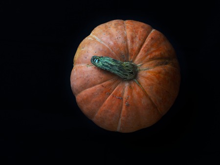 Fresh orange pumpkin isolated on black background. Top view.