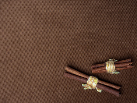Cinnamon sticks tied with string. On a nice brown background with a place for the inscription on the left.の写真素材
