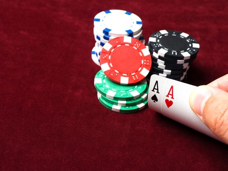 Pair of aces in a poker game. Poker chips, cards and red cloth. The concept of luck in the game.の写真素材