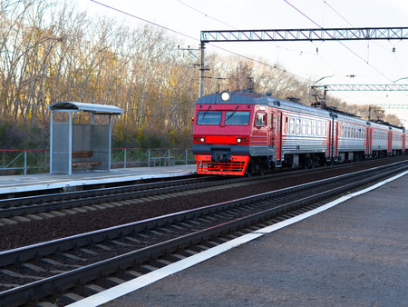 Red Train locomotive coming to platform Station Russia. Passengers on the right.