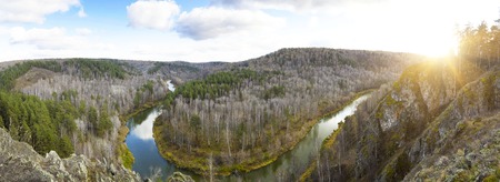 A beautiful bend of a river in a mountainous area. Autumn colors and reflections in the water. Sunny evening at sunset or sunrise in autumn.の写真素材