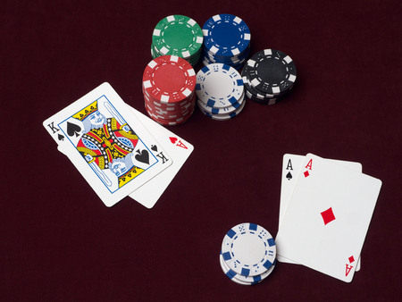 Poker chips and cards on red cloth. The chance to win back a player with aces, but his pot is too...