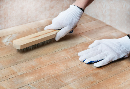Female's hands in white protective gloves handle the wooden surface with a metal brush. Isolating the texture of a wooden surface.の写真素材