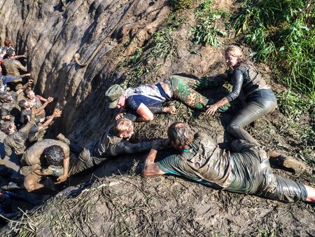 NOVOSIBIRSK, RUSSIA - 2 SEPTEMBER 2017. Young people pass the obstacle course. Mud race runners.