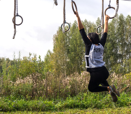 Young mans pass the obstacle course. Mud race runners. The girl passes the obstacle course. Stage...