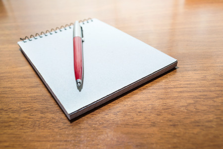 Spiral notepad and pen on the tableの写真素材