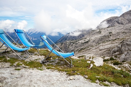 Three blue deck chairs in the mountainsの写真素材