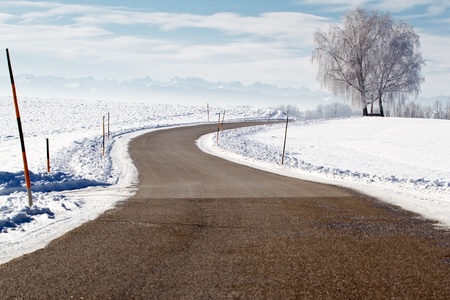Country road in winter with view of the alpsの写真素材
