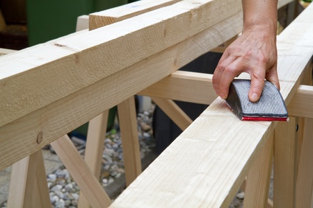 Manually grinding a wooden beamの写真素材