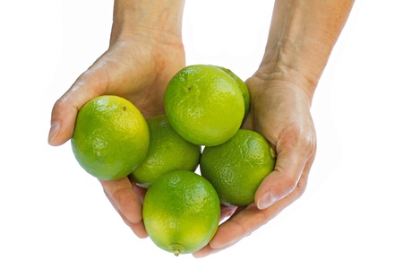 Female hands holding fresh limesの写真素材