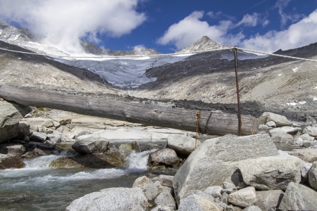 Provisional tiny bridge crossing a mountain stream in northern Italyの写真素材