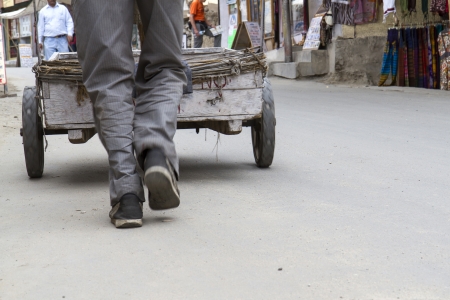 Man pushing an old wood-cart in Asia, Indiaの写真素材