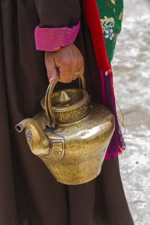 Ladhaki woman carries a tea pot, Ladakh, Indienの写真素材