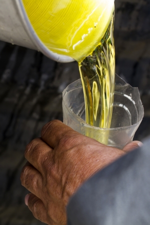 Pouring oil into a plastic cup, Ladakh, Indiaの写真素材