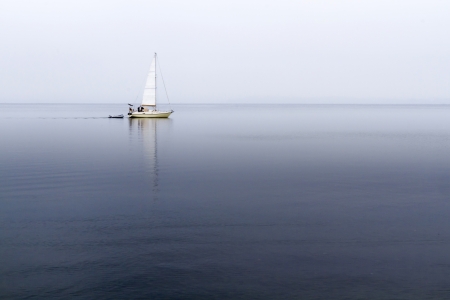 Lake Chiemsee, Germany, in autumn mist with sailboat の写真素材