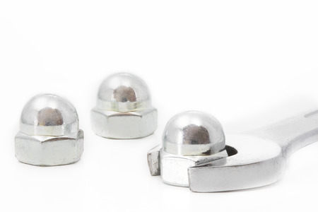 Domed cap nuts and wrench on white