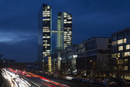 Busy road with office building in Munich, Germany, during the blue hourの写真素材