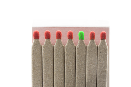 Matches with red and one green heads, isolated on white backgroundの写真素材