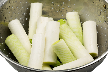Pieces of fresh leek in a colander with water dropsの写真素材